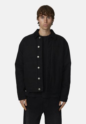 Zwarte denimjas met zilveren drukknoopsluitingen, een kraag en twee voorzakken, met een gestructureerde stof en een relaxed fit.