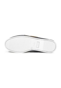 Schwarzer Sneaker mit einer weißen Gummisohle. Die strukturierte Sohle hat Rillen für besseren Halt. Der obere Abschnitt weist einen braunen Akzent auf und hat ein nahtloses Design.