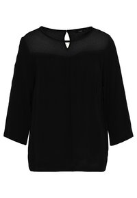 Blouse noire à manches trois-quarts, avec un panneau transparent au niveau du col et un petit détail en forme de trou à l'arrière. Texture de tissu lisse.