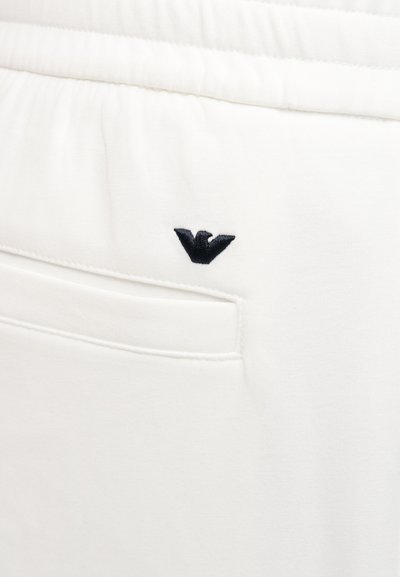 Λευκό παντελόνι από ύφασμα με ελαστική ζώνη στη μέση και μικρό μαύρο κεντητό λογότυπο αετού πάνω από μια πίσω τσέπη.