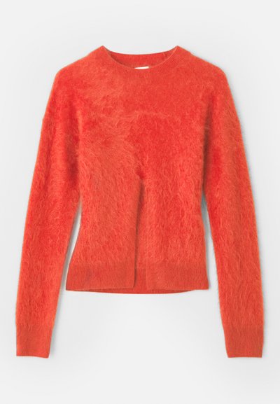 Rode, fuzzy trui met lange mouwen en een ronde halslijn. Heeft een licht oversized pasvorm en een ribbelrand aan de onderzijde.