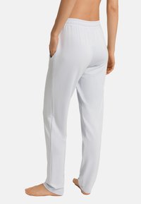 Ljusblå, lätta träningsbyxor med avslappnad passform, elastisk midja, sidofickor och en slät, mjuk textur.