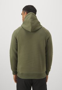 Olivengrøn hættetrøje med snøre i hætten, ribbede manchetter og kant, blød tekstur og tætsiddende design, set bagfra.