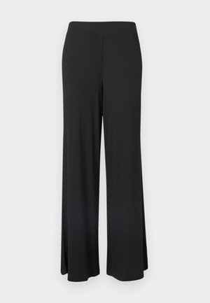 Svarta, vida byxor i ribbad tyg. Har resårmidja och en flödande design med vertikal textur. Inga fickor eller dekorationer.