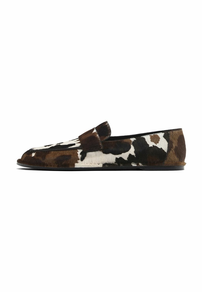 Loafer with a cowhide leather exterior featuring a brown and white patchwork pattern. Low profile with a rounded toe and flat black sole.