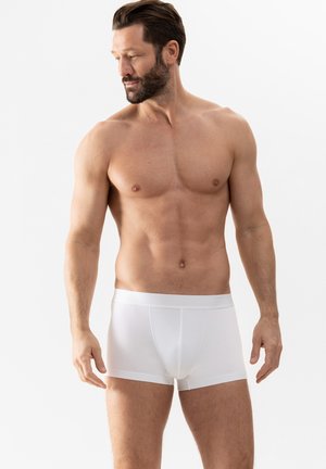 Witte katoenen boxershorts met een gladde textuur en elastische tailleband, een aansluitend ontwerp dat de romp en benen benadrukt.