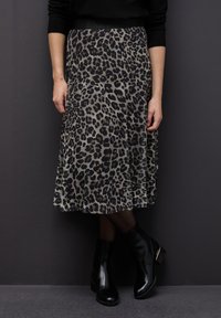 Midi sukně s leopardím potiskem a volnou texturou, černý pás, spárovaná s kotníkovými bootami s elegantním designem a zlatými detaily.