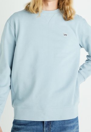 Felpa azzurro chiaro in misto cotone, con scollo e polsini a costine, e piccolo logo "Lee" ricamato sul petto.