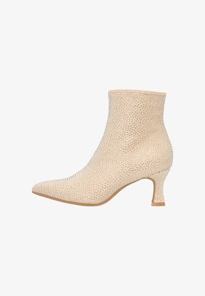 Beige Knöchelschuhe aus strukturiertem Material, die mit kleinen Strasssteinen bedeckt sind, mit einer spitzen Zehenpartie und einem kurzen, transparenten Absatz.