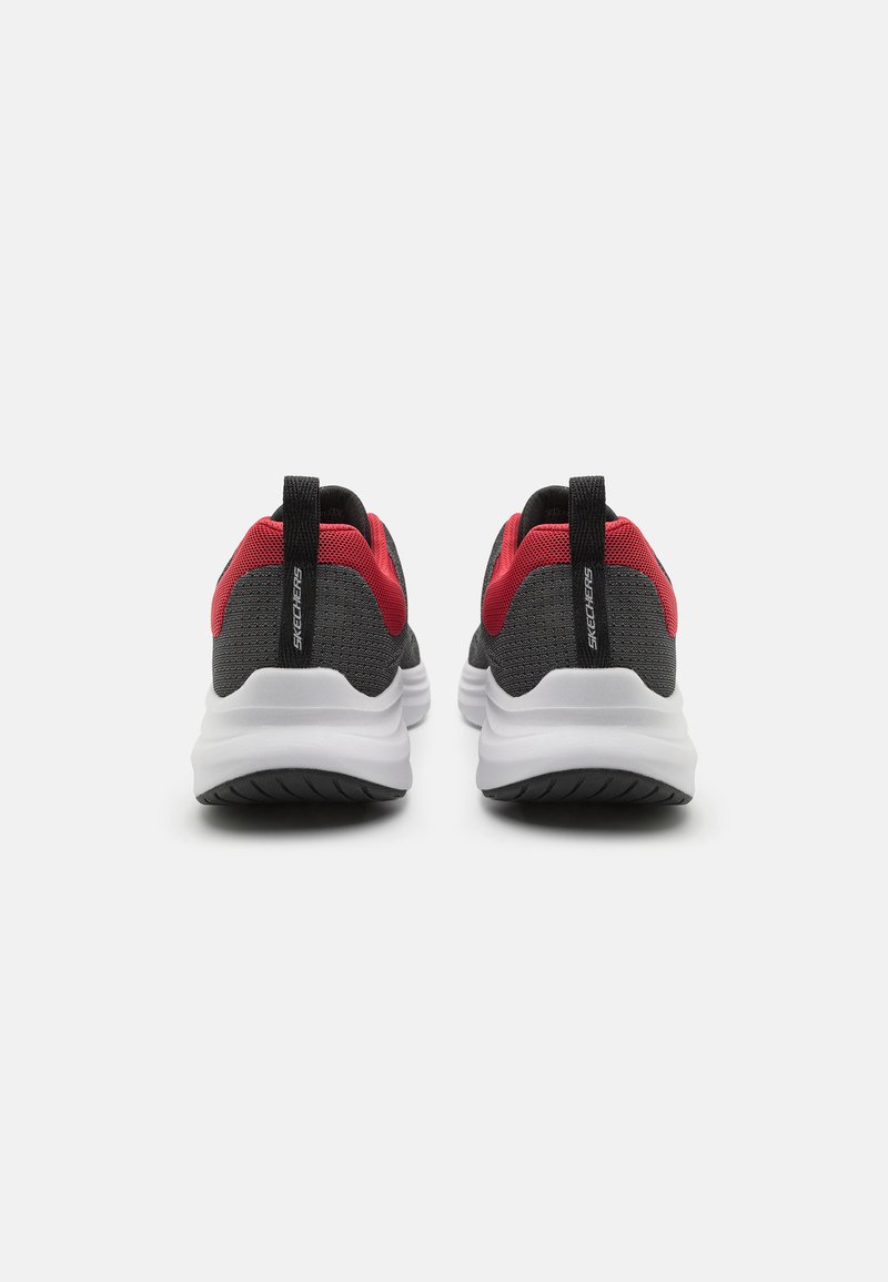Zapatillas deportivas negras y rojas con una parte superior de malla, suela blanca acolchada y una pestaña en la parte trasera para facilitar su puesta.