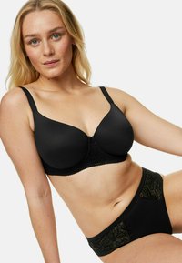 Reggiseno nero e mutandine coordinate, realizzati in tessuto liscio con dettagli in pizzo. Il reggiseno presenta coppe sagomate e spalline regolabili.
