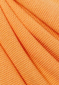 Strickstoff in leuchtendem Orange, mit einem strukturierten, gerippten Muster und einer feinen, dichten Webart. Weiches und flexibles Material.