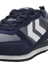 Sinine ja hall spordijalanõud, mis on valmistatud luksuslikest suede ja võrgumaterjalidest, valged chevroni aktsendid, tekstureeritud shoelaces ja kummist tald.