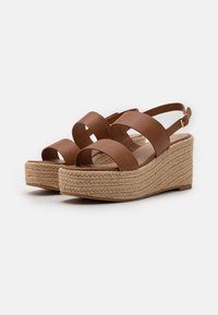 Brune plattform sandaler med brede kryssede stropper, sone dekket med jute og slingback-design. Glatt overmateriale og en gullspenne.