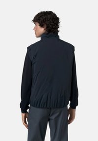 Gilet senza maniche blu scuro con colletto alto, vita elastica e maniche nere a contrasto, realizzato in un tessuto liscio e leggero.
