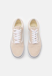 Beige semskinn sneakers med hvite snøringer, kontrasterende side stripe, gummisåle og rund tå. Rent design med minimale detaljer.