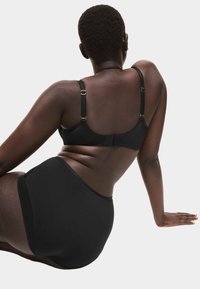 Sort BH og højtaljet trusse i glat stof. Har justerbare stropper med guldfarvet beslag. Enkel, minimalistisk design.