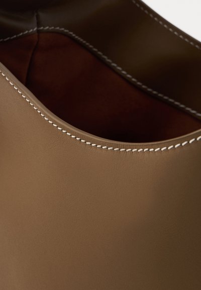 Brown leather tote bag with a smooth texture, featuring white stitching along the edge and an open, seamless design.