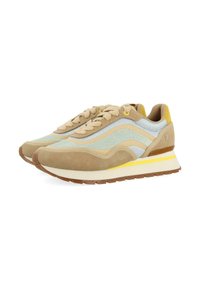 Zapatillas de ante beige con acentos en azul claro y amarillo, que presentan franjas laterales curvadas, puntera redonda, diseño con cordones y suela de goma.