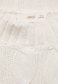 Weißer Strickpullover mit einem Kabelstrickmuster, geripptem Kragen und einem Etikett mit Marken- und Größenangaben. Weicher Textur und leichtes Design.