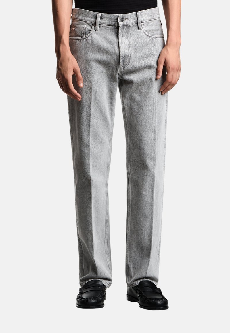 Jeans in denim grigio chiaro con vestibilità dritta, dotati di cinque tasche, cuciture a contrasto e chiusura con bottoni.