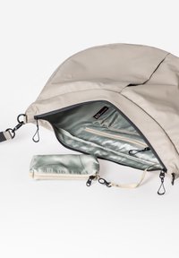 Beige Stoff-Schultertasche mit einem glatten, glänzenden Innenraum. Verfügt über eine Reißverschlusstasche, einschließlich eines kleinen passenden Beutels mit Reißverschluss.
