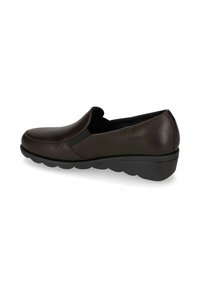 Scarpa mocassino in pelle marrone con punta arrotondata, pannelli laterali elastici e una spessa suola in gomma nera. Texture liscia con dettagli di cucitura minimi.