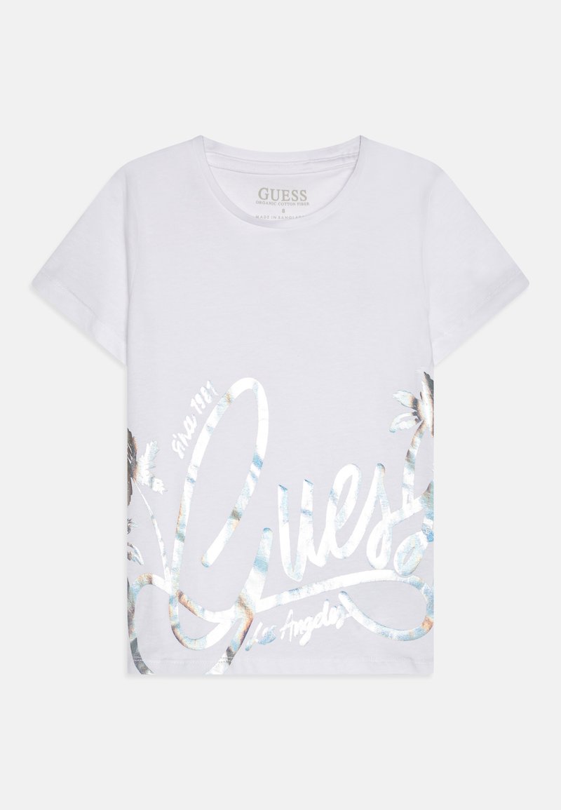 Balta kokvilnas T-krekls ar lielu metāla logo dizainu zilos un zeltainos toņos, ar ziedu akcentiem kreisajā apakšējā stūrī.