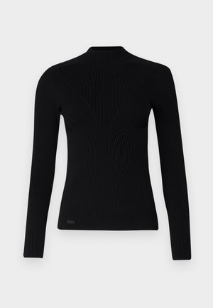 Sort ribbet trøje med lange ærmer og høj hals, der har en tætsiddende form og struktureret stof. Litet logo nederst til venstre.