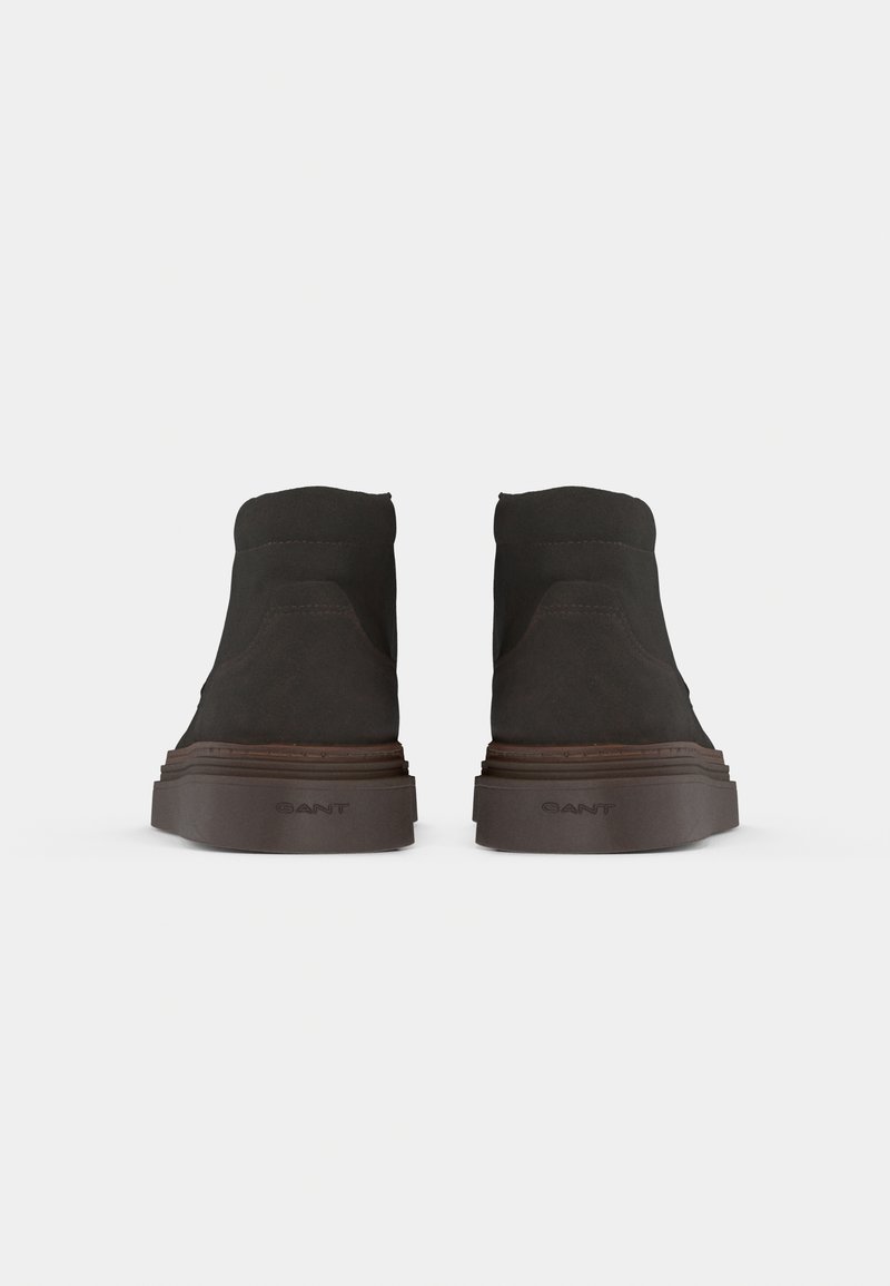 Bottines en daim noir avec un dessus texturé, bout rond et une épaisse semelle en caoutchouc. Logo "GANT" visible sur le talon. Design plat.