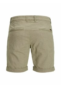 Shorts beige pour hommes avec revers roulés, poches zippées à l'arrière, passants pour ceinture et une petite étiquette logo rectangulaire en cuir du côté droit.