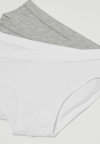 Trois paires de sous-vêtements pour femmes : une blanche, une gris clair et une gris foncé. Le tissu est lisse, avec des ceintures élastiques et en coton.