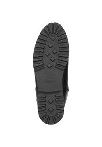 Schwarze Gummisohle mit tiefen Profilen, ausgestattet mit einem strukturierten Muster und einem zentralen Logo; robuste Bauweise für Traktion und Haltbarkeit.