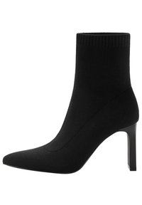 Bottine noire à cheville avec tige en maille texturée, bout pointu et talon haut fin. Le col côtelé ajoute du détail au design épuré.