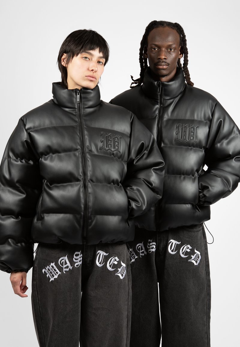 Black padded jackets with glossy texture and high collars, featuring a logo on the chest. Worn over dark gray pants with white text.
