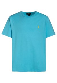 Camiseta de algodón azul claro con mangas cortas y cuello redondo, que presenta un pequeño logo amarillo en el pecho. Fit clásico y textura suave.
