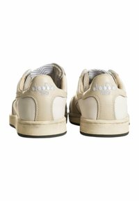 Sneakers in pelle beige con suola testurizzata, fodera morbida e branding bianco sul tallone. Caratterizzati da un design classico a bassa cima.