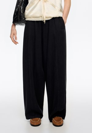 - Spodnie materiałowe