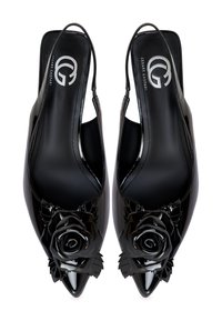 Chaussures à talons slingback en cuir verni noir avec des bouts pointus, ornées d'un grand embellissement brillant en forme de rose et de feuilles sur le dessus.