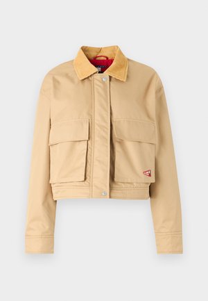 Cropped beige jacket with a corduroy collar, front snap closure, and two large chest pockets. Features a red interior lining and logo patch.