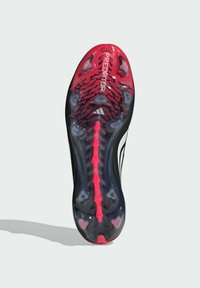 Μαύρη και κόκκινη σόλα ποδοσφαιρικού παπουτσιού με υφή, που φέρει χαρακτηριστικό μοτίβο, διαφανή σταθερά και έντονα λευκά γράμματα.