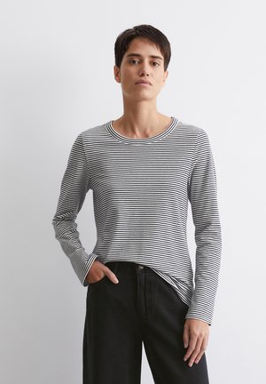 Schwarz-weiß gestreiftes Langarmshirt mit Rundhalsausschnitt, weichem Stoff und geradem Schnitt, kombiniert mit schwarzen Hosen.
