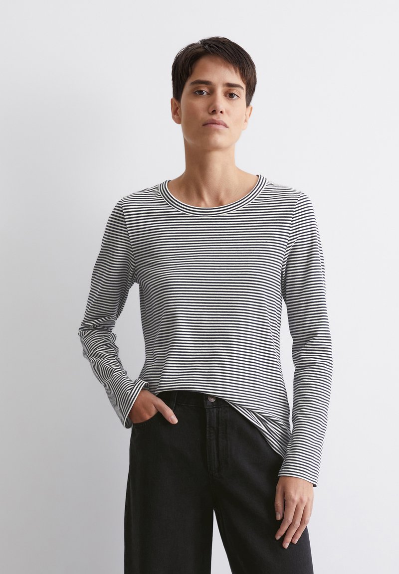 Schwarz-weiß gestreiftes Langarmshirt mit Rundhalsausschnitt, weichem Stoff und geradem Schnitt, kombiniert mit schwarzen Hosen.