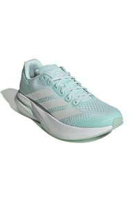 Zapatilla atlética de un suave verde menta con parte superior de malla, detalles en rayas blancas y suela acolchada. Presenta cordones y un cuello acolchado para mayor comodidad.