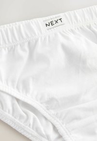 Hvide bomuldsunderbukser med elastisk linning prydet med "NEXT"-mærket. Glat tekstur, samlede sider og enkelt design.