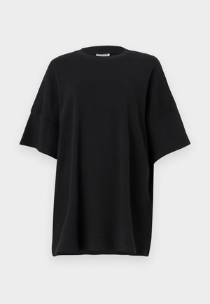 Svart oversized t-shirt i bomull, med rund halsringning och korta, vida ärmar som har en mjuk textur och avslappnad passform.