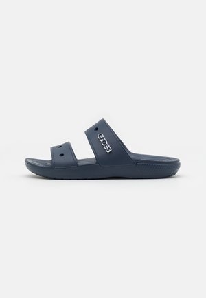 Granatowy sandał typu slide Crocs z dwoma paskami i otworami wentylacyjnymi, z logo Crocs na górnym pasku, widok z boku.