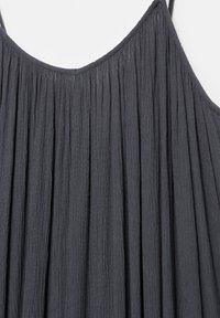Robe noire plissée sans manches avec fines bretelles et un décolleté légèrement arrondi.