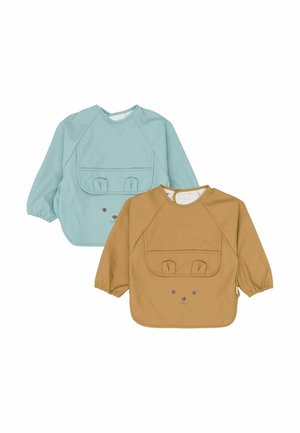 To børneforklæder: et i lyseblåt og et i beige. Begge har et print af en kaninansigt samt en lomme med ører som detaljer. Blødt, let materiale.
