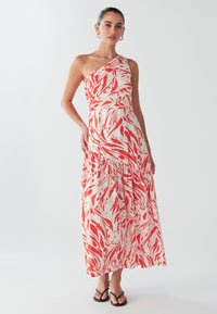 Maxikleit, millel on ühe õlaga disain, valge kangas punaste abstraktsete mustritega, astmeline ääreosa ja kerge tekstuur.